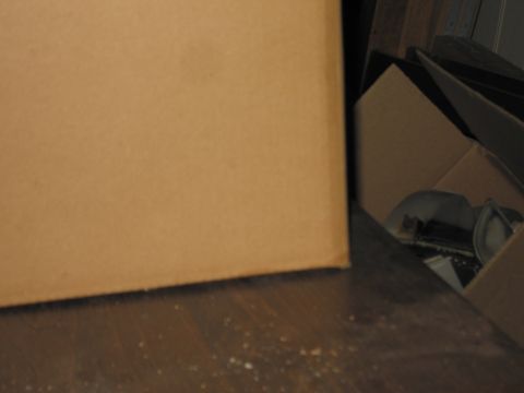2001 Ford Crown Victoria - Cardboard boxes are piled on a wooden surface, with some items visible inside one of the boxes.