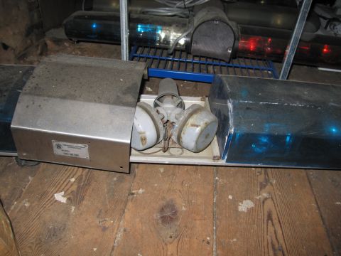 2001 Ford Crown Victoria - A dusty police light bar with blue lenses and visible siren components sits on a wooden floor.