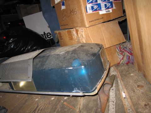 2001 Ford Crown Victoria - A dusty blue light bar is stored indoors amongst cardboard boxes and other items.