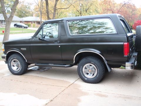 1993 Ford Bronco - This black Ford Bronco SUV is seen from the side, showing its chrome accents and off-road tires.