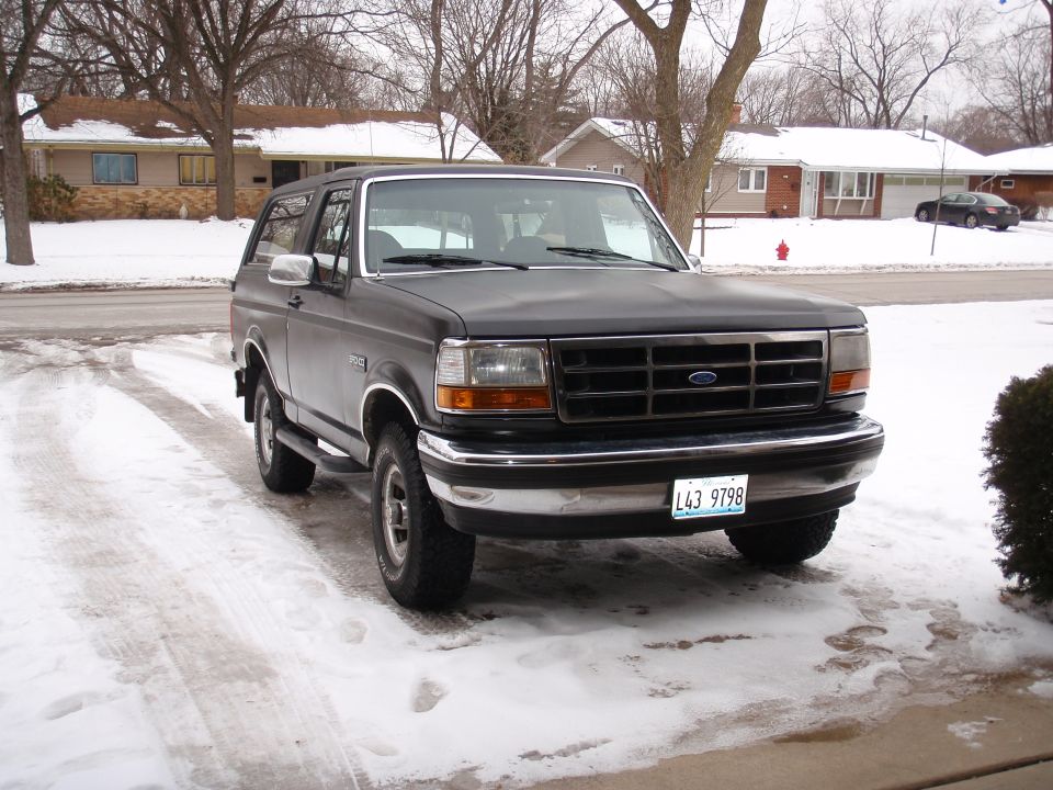 Dark 1993 Ford Bronco front quarter view in snowy driveway