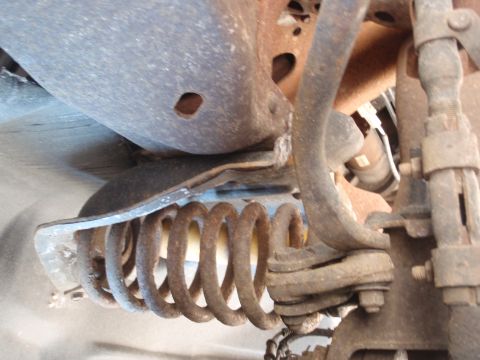 1993 Ford Bronco - Close-up view of the front suspension spring and associated components on a 1993 Ford Bronco.