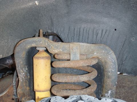 1993 Ford Bronco - Close-up of a vehicle's front suspension system, showing a coil spring and shock absorber.
