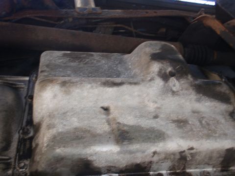 1993 Ford Bronco - Close-up view of a Ford oil pan, showing the manufacturer's emblem and signs of wear.