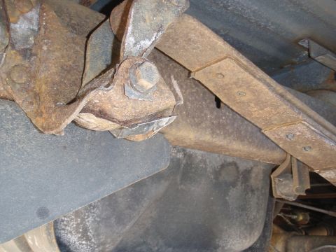 1993 Ford Bronco - Close-up of heavily rusted leaf spring and suspension parts, likely from an older vehicle.