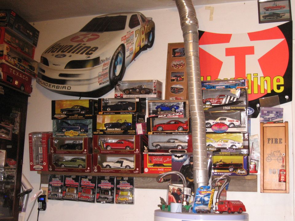 Model car collection with racing decals and memorabilia on a wall