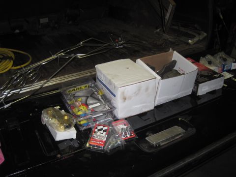 1979 Ford Bronco - Automotive parts and boxes are laid out on a black surface, with some items from Earl's Performance Parts visible.