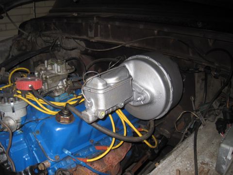 1979 Ford Bronco - Close-up of an engine bay showing the brake booster and carburetor assembly.