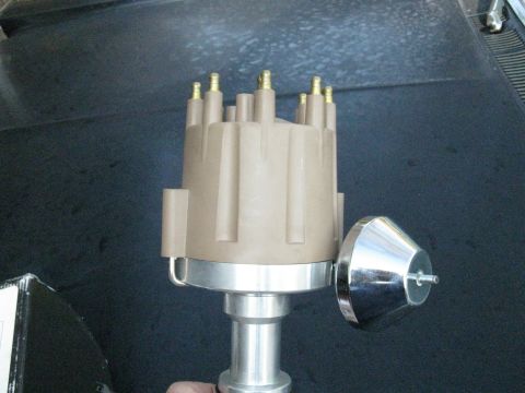 1965 Ford Galaxie - A tan distributor cap and chrome rotor are shown in detail against a dark background.