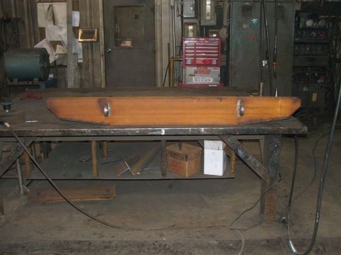 1978 Ford Bronco - A fabricated steel bumper with integrated tow loops rests on a metal workbench in a workshop setting.