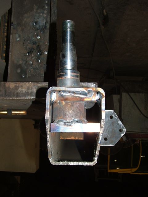 1978 Ford Bronco - A close-up view of a custom-welded metal bracket attached to a vehicle spindle.