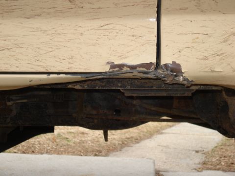 1985 Ford Bronco - Rust damage is visible on the frame and lower body panel of this vehicle.