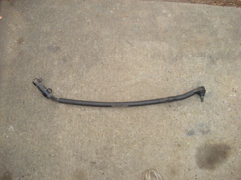 1985 Ford Bronco - A single steering linkage rod is shown on a concrete surface.