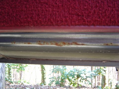 1986 Ford Bronco - Close-up view of the interior trim and undercarriage, showing signs of rust.