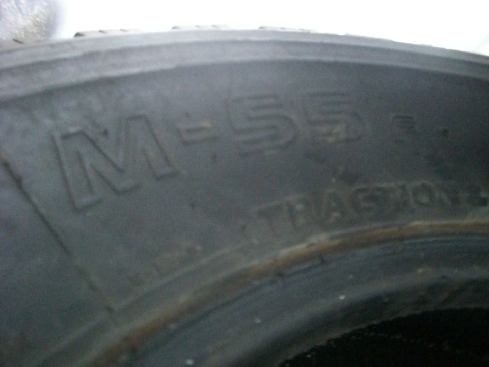 Close-up of a tire sidewall showing "M-55" and "TRACTION"