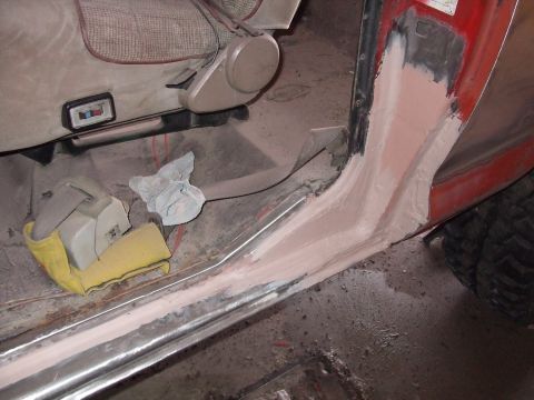1979 Ford Bronco - Bodywork is underway on the interior door sill of a vehicle, with a tan seat visible.