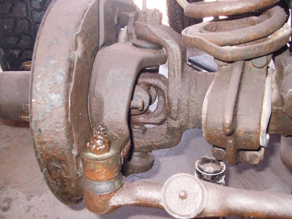 Close-up of rusty front suspension parts and tire tread