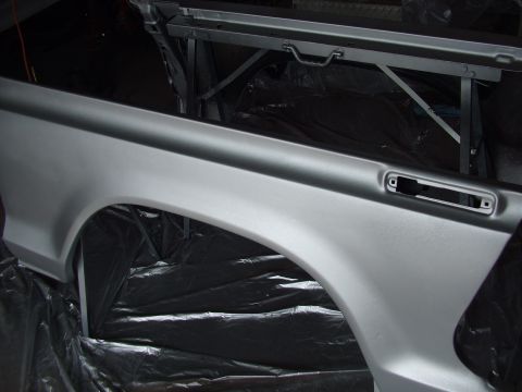 1979 Ford Bronco - Vehicle body panel, likely a fender and bed side, undergoing preparation or painting.
