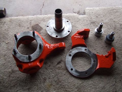 1979 Ford Bronco - These are vehicle suspension parts, likely steering knuckles and related components, laid out for inspection or assembly.