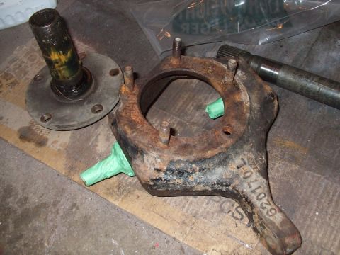 1979 Ford Bronco - Close-up of disassembled vehicle front axle components, including a spindle and hub assembly.