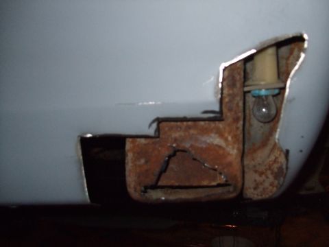 1979 Ford Bronco - Close-up of rusted metal panel with a light bulb socket visible.