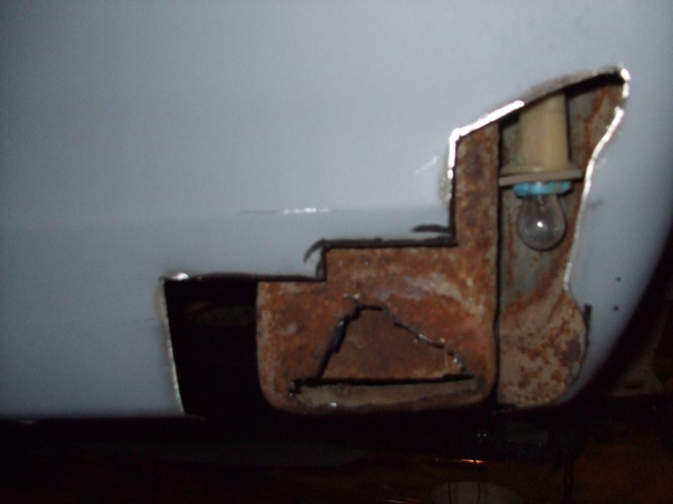 rusted metal panel showing damage and a light bulb socket