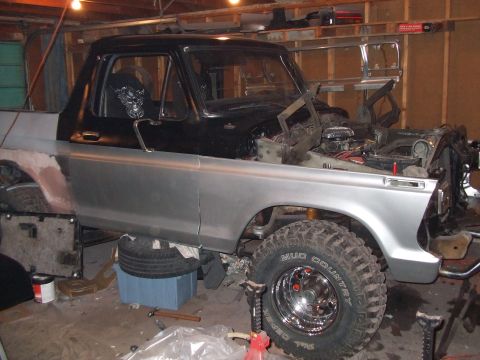 1979 Ford Bronco - This Ford truck, likely from the mid-1970s, is undergoing extensive bodywork and mechanical repairs in a garage setting.