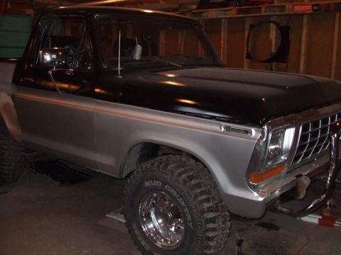 1979 Ford Bronco - This lifted Ford Bronco is parked in a garage, showing off its two-tone paint and tires.