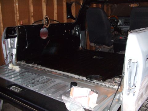 1979 Ford Bronco - The interior of a 1979 Ford Bronco is visible, with the tailgate down and the dashboard in view.