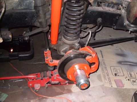 1979 Ford Bronco - Close-up view of a vehicle's front suspension and braking system undergoing maintenance.