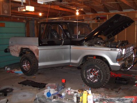 1979 Ford Bronco - This Ford truck is in a garage with its hood open, showing the engine bay and various tools around it.