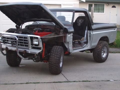 1979 Ford Bronco - This 1979 Ford Bronco is shown with its hood open, revealing the engine and a two-tone silver and black exterior.