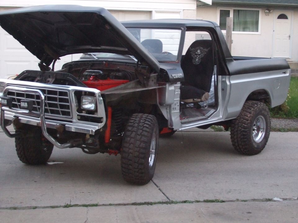1979 Ford Bronco with hood open, showing red engine and silver body