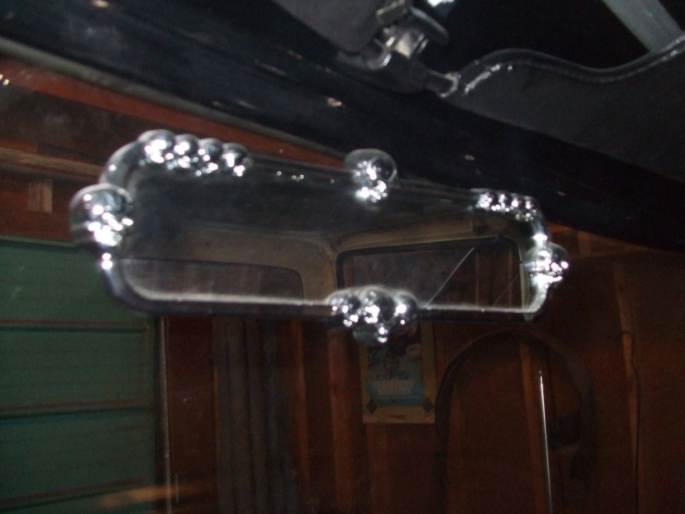 Chrome trim on interior rearview mirror, reflection shows part of the vehicle interior