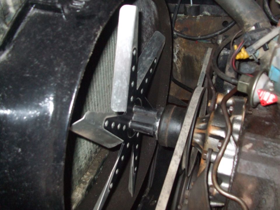 Engine fan with metal blades and a pulley system with a belt