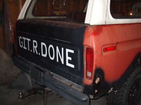 1979 Ford Bronco - The rear of a Ford Bronco shows custom text on the tailgate and signs of wear and tear.