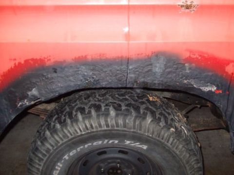1979 Ford Bronco - The rear wheel well of this vehicle shows significant rust and wear around the tire.
