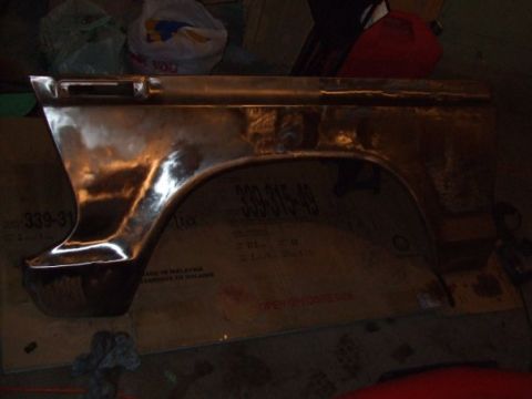 1979 Ford Bronco - A close-up of a bare metal vehicle fender part sits on top of a cardboard box.