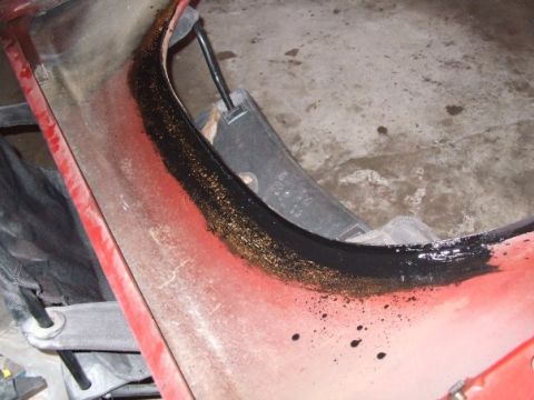 1979 Ford Bronco - The underside of a vehicle's fender well shows some wear and tear with black undercoating applied.