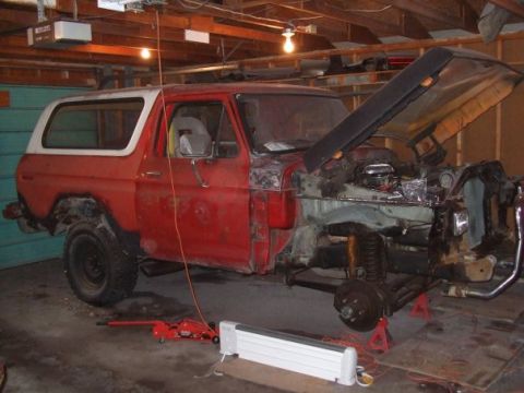 1979 Ford Bronco - This red SUV, likely a 1978 model, is in a garage with its hood up and front end removed for repairs.