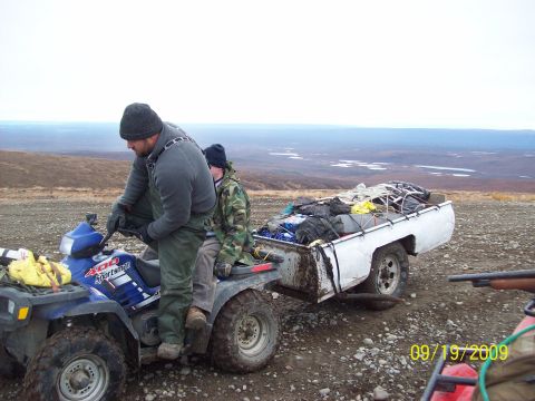 1986 Chevrolet Blazer - A white pickup truck bed, loaded with gear, is parked on a rocky surface with a vast landscape in the background.