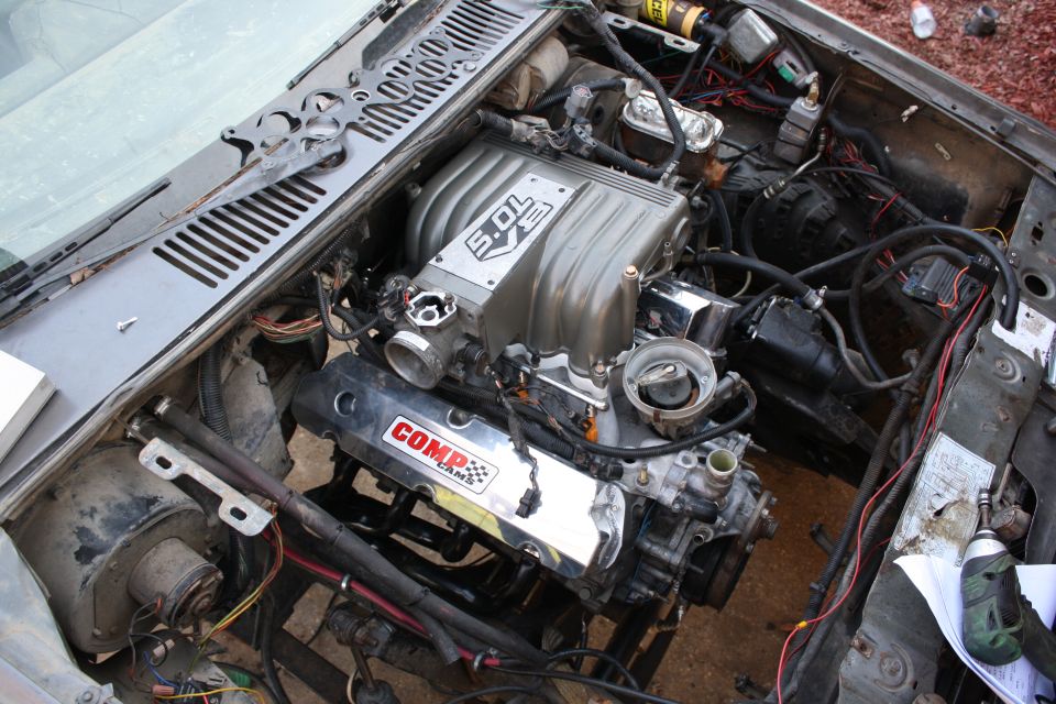 Ford 5.0L V8 with Comp Cams valve cover installed in an engine bay mid-swap