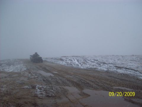 1986 Chevrolet Blazer - An all-terrain vehicle navigates a muddy and snowy path on a foggy day.