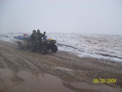 1986 Chevrolet Blazer - ATV being towed by a truck in snowy conditions on a dirt road.