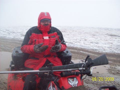 1986 Chevrolet Blazer - A person rides an ATV on a beach during a snowstorm.
