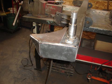 1989 Ford Bronco - A custom-fabricated metal part, possibly a suspension component, is shown secured in a vise on a workbench.