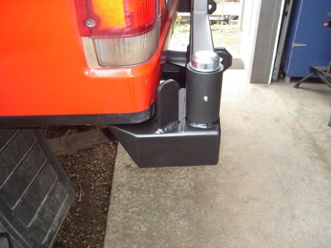 1989 Ford Bronco - Aftermarket rear bumper and spare tire carrier mounted on an orange vehicle.