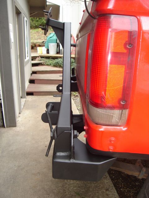 1989 Ford Bronco - Aftermarket rear bumper and spare tire carrier assembly attached to a vehicle's rear.