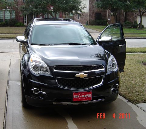 2011 Chevrolet Equinox - A black 2011 Chevrolet Equinox is shown parked in a driveway with the front passenger door ajar.