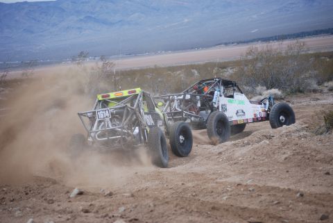 1982 Ford Bronco - Two off-road vehicles compete on a dusty desert course, with one prominently displaying the number 1614.